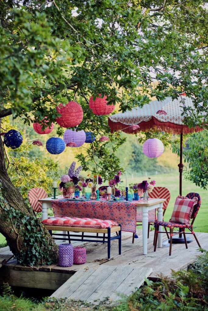 Colourful Dunelm outdoor floral dining table setting with lanterns.