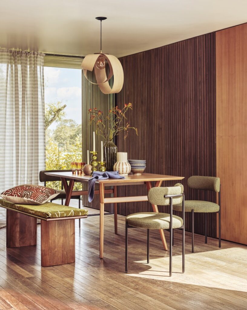 Mid-century 1970's style dining bench and table . Wooden paneling, modern apartment . Large full length windows.