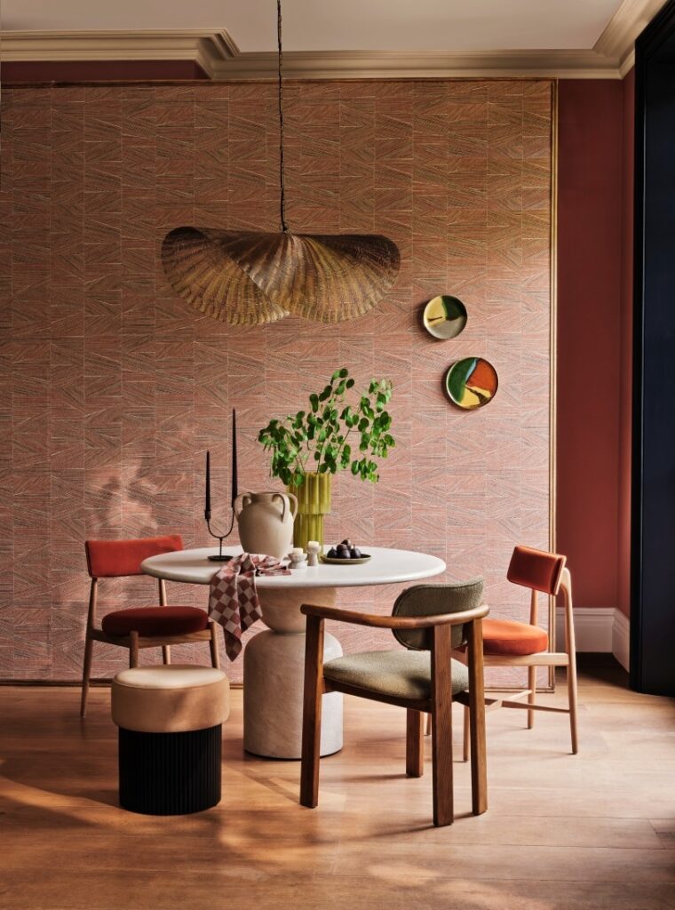 Coral textured pattern wallpaper metal wicker overhead light round stone dining room table